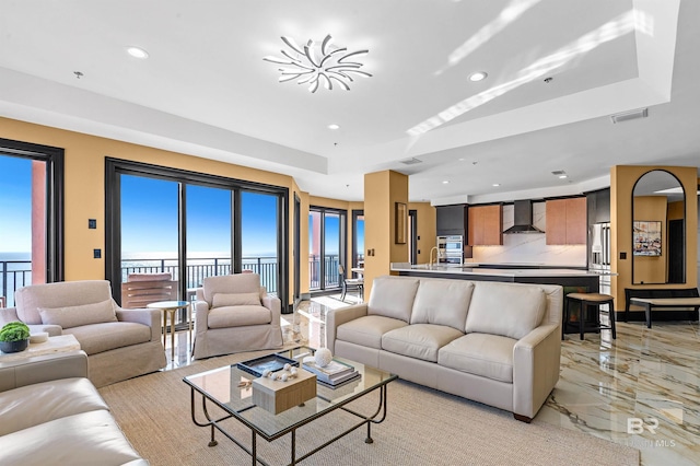 living area featuring recessed lighting, marble finish floor, visible vents, and a raised ceiling