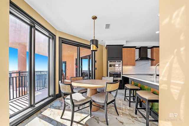 dining area with a wealth of natural light, marble finish floor, and visible vents