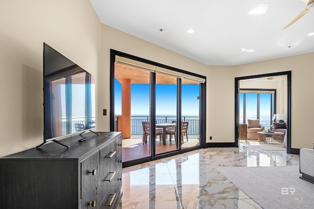 doorway with marble finish floor, baseboards, and recessed lighting