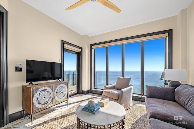 living area with ceiling fan and baseboards