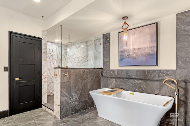 full bathroom featuring a freestanding tub, a marble finish shower, marble finish floor, and tile walls