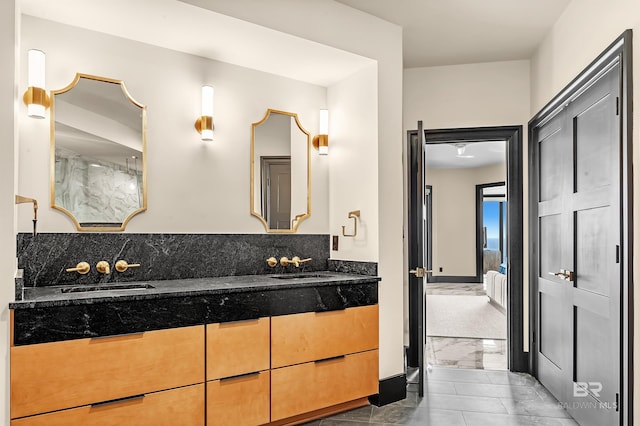 bathroom with double vanity, marble finish floor, and a sink