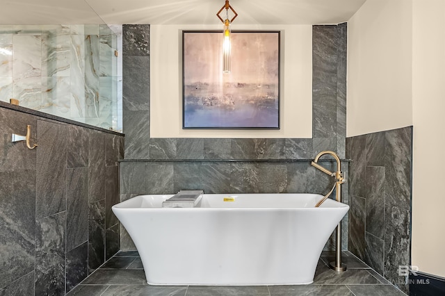 full bathroom with a soaking tub, a shower, and tile walls