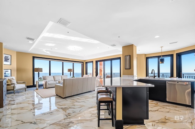 kitchen with marble finish floor, visible vents, a kitchen breakfast bar, and dishwasher