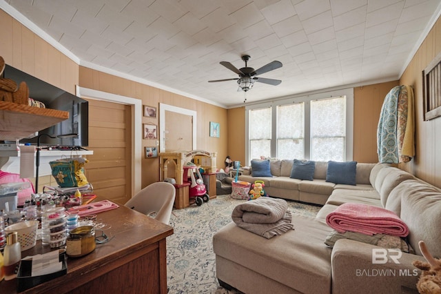 living room featuring crown molding, ceiling fan, and wood walls