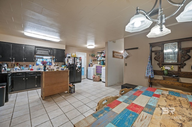 kitchen featuring black fridge with ice dispenser, light tile patterned floors, electric range, and washer and clothes dryer