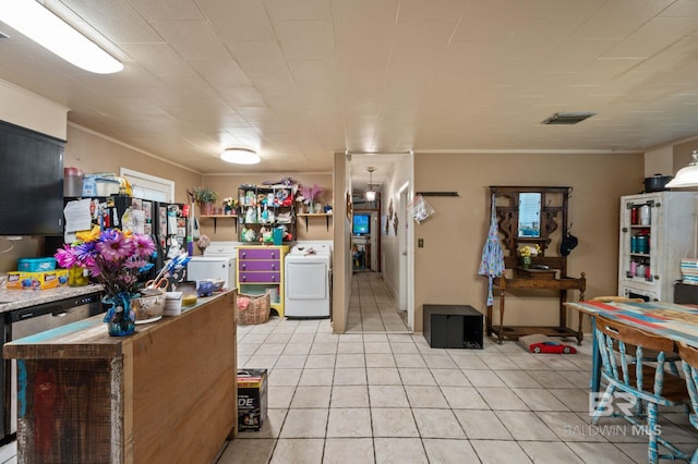 kitchen featuring ornamental molding, light tile patterned flooring, and washer and clothes dryer