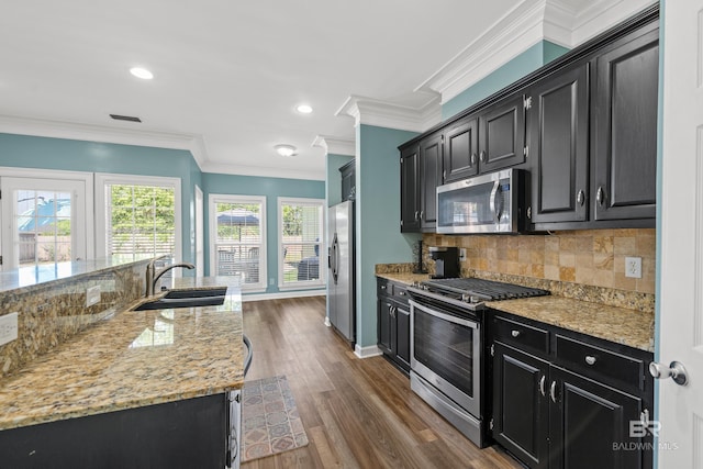 19083 County Road 13, Fairhope, AL 36532 - kitchen with appliances with stainless steel finishes, a sink, dark cabinets, tasteful backsplash, and crown molding