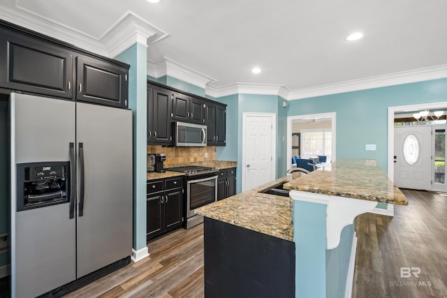 19083 County Road 13, Fairhope, AL 36532 - kitchen with appliances with stainless steel finishes, crown molding, a breakfast bar, tasteful backsplash, and wood finished floors