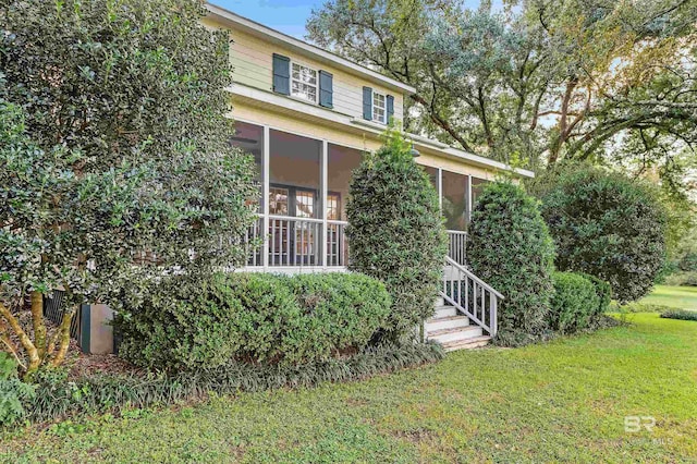 view of front facade featuring a sunroom and a front yard