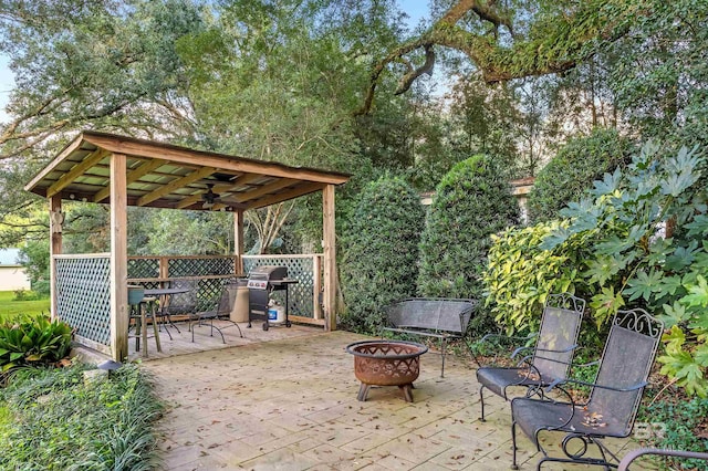 view of patio with an outdoor fire pit, area for grilling, and ceiling fan