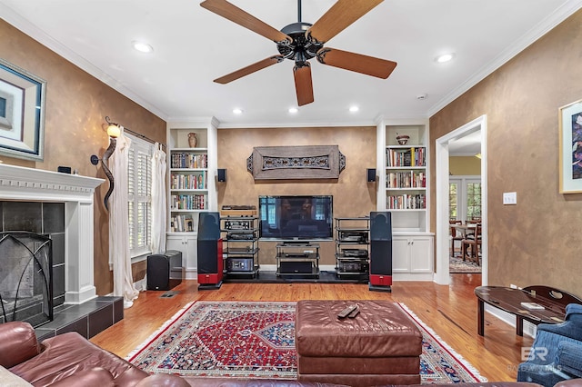 living room featuring a fireplace, plenty of natural light, hardwood / wood-style floors, and ceiling fan