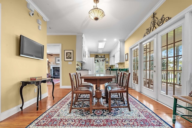 dining space featuring french doors, light hardwood / wood-style flooring, and crown molding