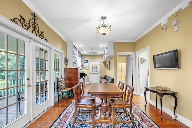 dining space with wood-type flooring and crown molding