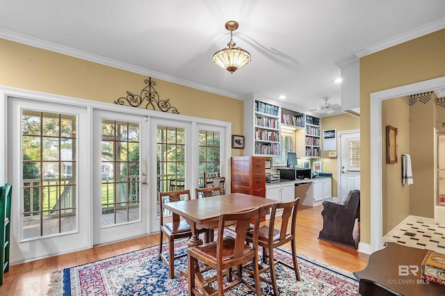 dining room featuring light wood-type flooring, crown molding, ceiling fan, and french doors