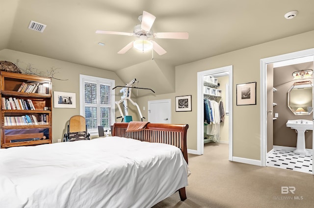 carpeted bedroom with lofted ceiling, a spacious closet, a closet, and connected bathroom