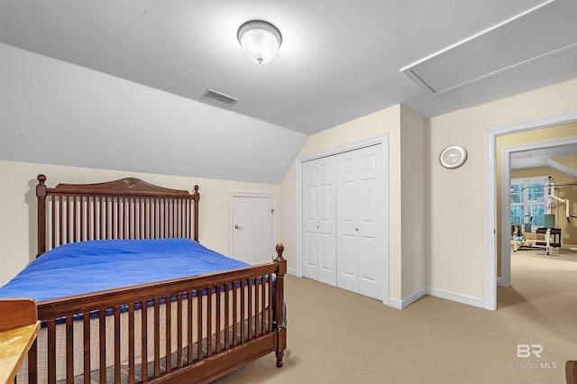 carpeted bedroom featuring a closet and vaulted ceiling