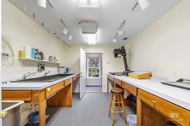 kitchen featuring carpet floors, a textured ceiling, sink, and a breakfast bar