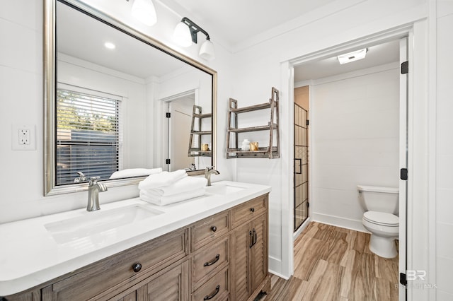 bathroom featuring hardwood / wood-style floors, vanity, toilet, ornamental molding, and an enclosed shower