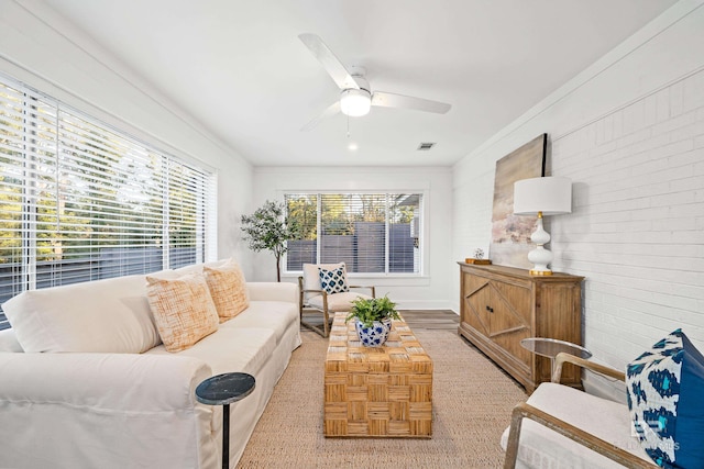 living room featuring wood-type flooring, ceiling fan, and crown molding