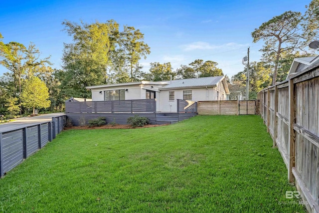 back of property featuring a lawn and a deck