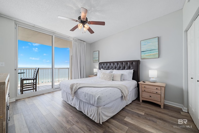 bedroom with a water view, a closet, floor to ceiling windows, and access to outside