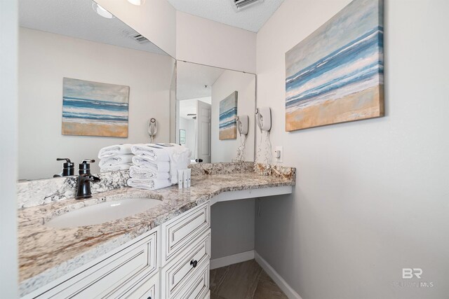 bathroom with vanity and a textured ceiling