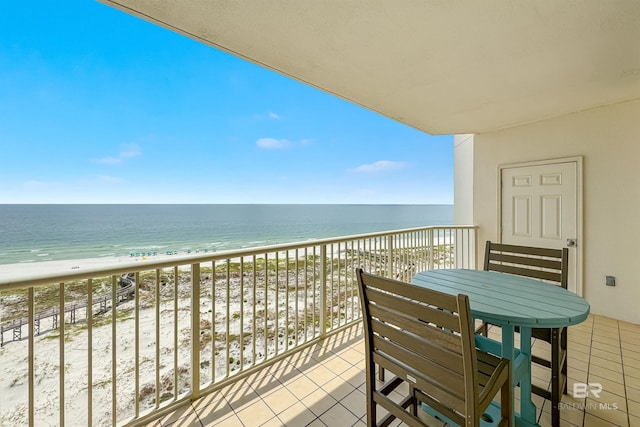 balcony featuring a view of the beach and a water view