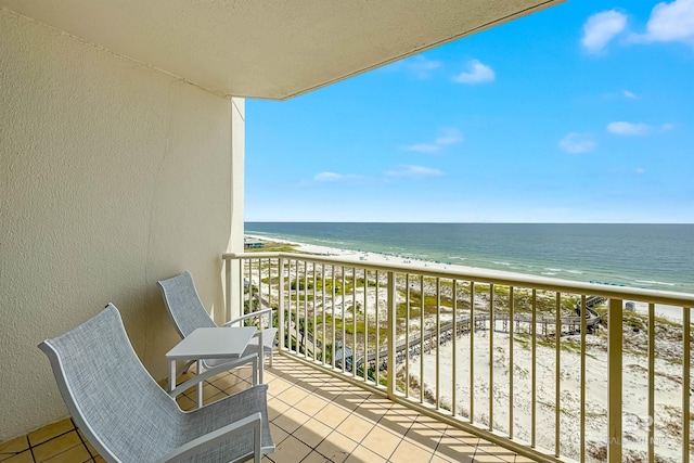 balcony featuring a water view and a view of the beach