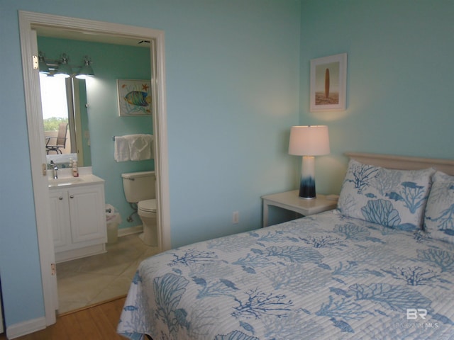 527 Beach Club Trl Unit D710, Gulf Shores, AL 36542 - bedroom with a sink, wood finished floors, connected bathroom, and baseboards