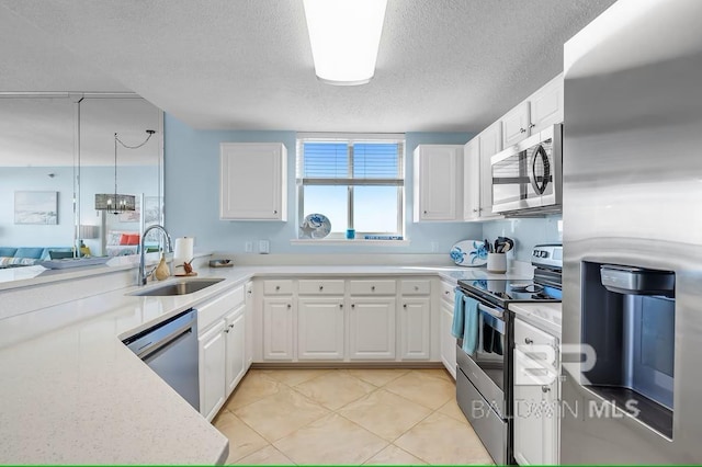 527 Beach Club Trl Unit D710, Gulf Shores, AL 36542 - kitchen featuring stainless steel appliances, a sink, a textured ceiling, and white cabinetry