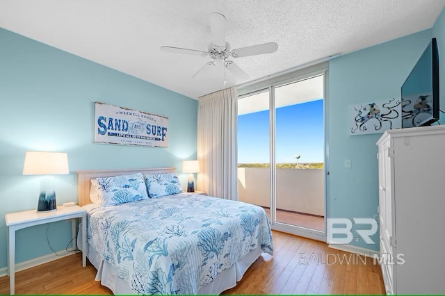 527 Beach Club Trl Unit D710, Gulf Shores, AL 36542 - bedroom featuring access to outside, light wood finished floors, baseboards, ceiling fan, and a textured ceiling