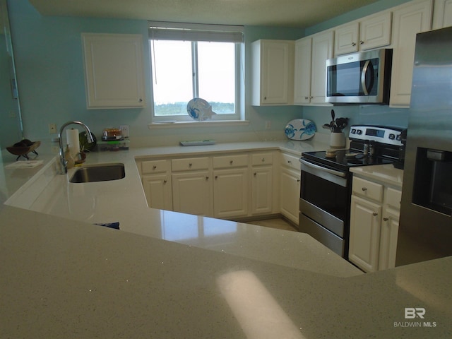 527 Beach Club Trl Unit D710, Gulf Shores, AL 36542 - kitchen with appliances with stainless steel finishes, a sink, white cabinets, and light stone countertops