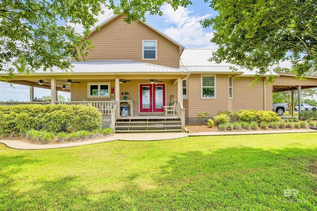 farmhouse with a ceiling fan, a front lawn, and metal roof