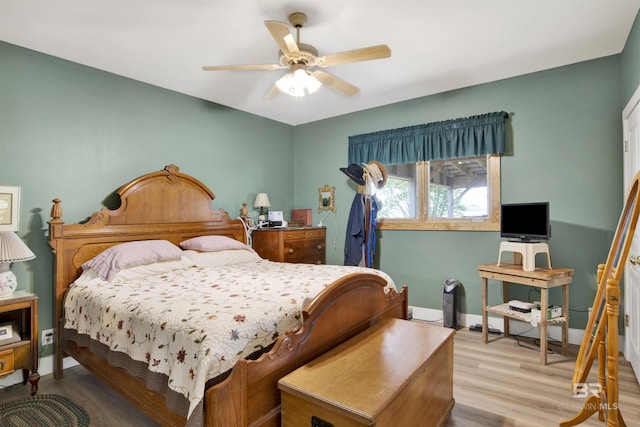 bedroom featuring wood finished floors, baseboards, and ceiling fan
