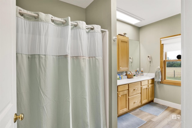 bathroom featuring wood finished floors, vanity, baseboards, and a shower with shower curtain