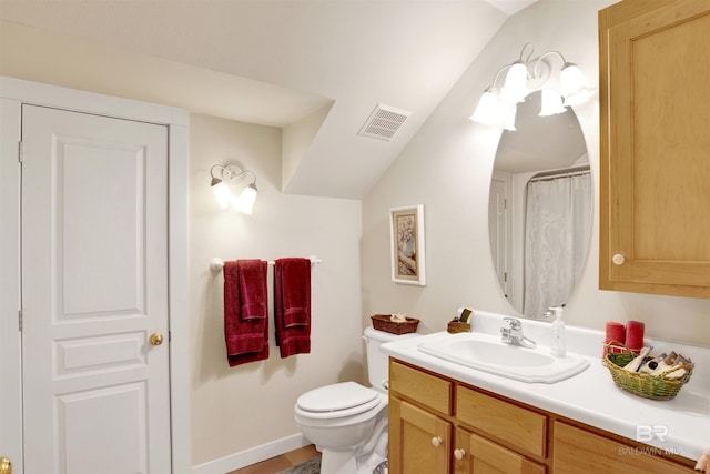 full bath with toilet, vanity, and vaulted ceiling