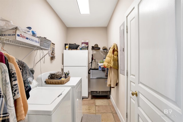 clothes washing area with washer and clothes dryer, baseboards, and light stone finish floors