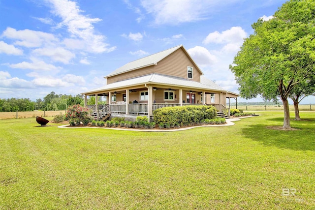rear view of house with a porch, a ceiling fan, and a lawn
