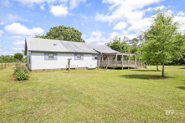 back of house featuring a yard, crawl space, metal roof, a deck, and a pergola