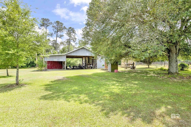 view of yard featuring a pole building, an outbuilding, and a carport