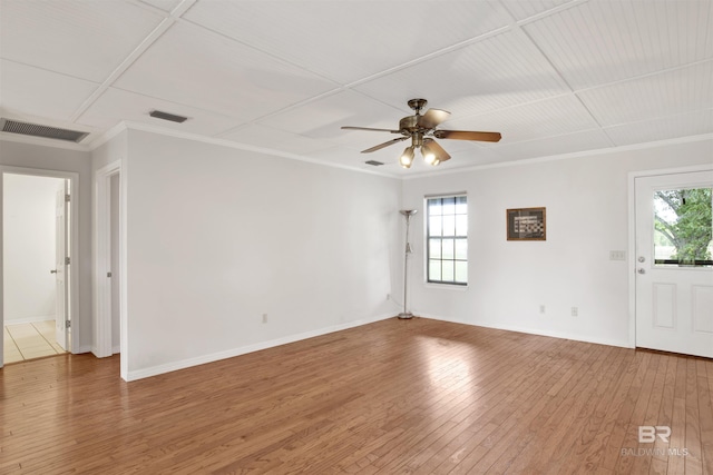 unfurnished room with healthy amount of natural light, ornamental molding, ceiling fan, and wood-type flooring