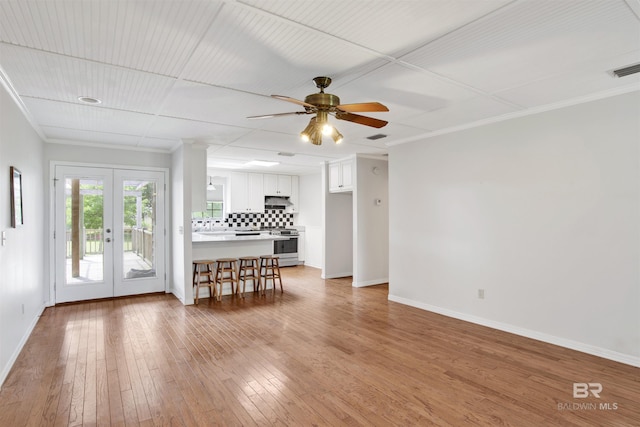 living area with baseboards, french doors, light wood finished floors, crown molding, and ceiling fan