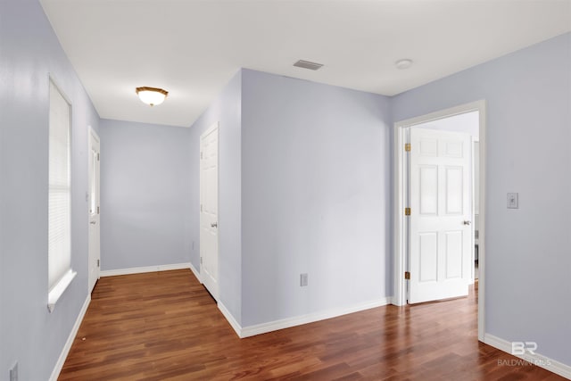 corridor with wood finished floors and baseboards