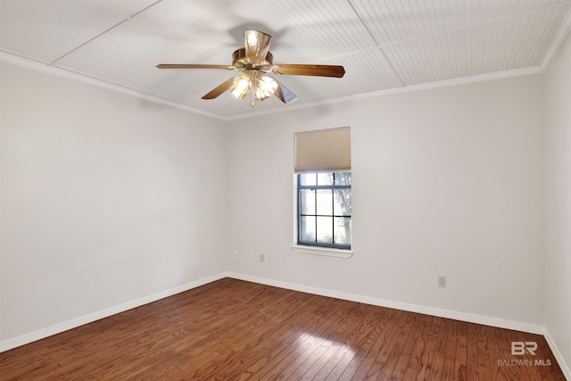 spare room featuring wood-type flooring, baseboards, a ceiling fan, and crown molding