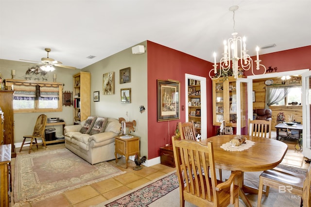 dining space with a chandelier, a ceiling fan, baseboards, and light tile patterned floors