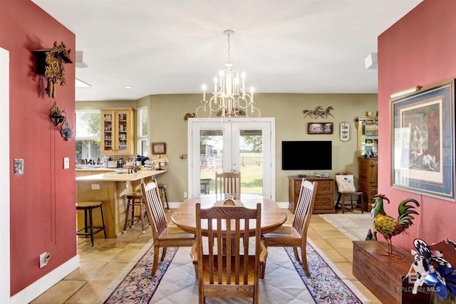 dining room featuring french doors, light tile patterned flooring, a chandelier, and baseboards