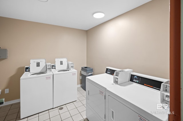 washroom with washing machine and clothes dryer and light tile flooring