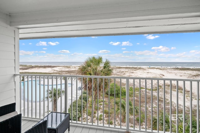 balcony featuring a view of the beach and a water view