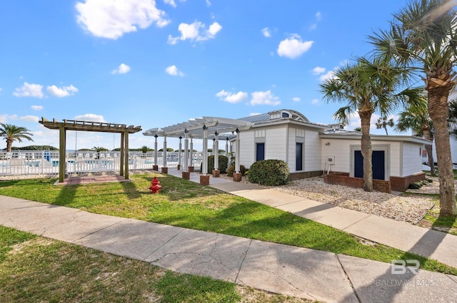 view of front of property with a pergola and a front yard